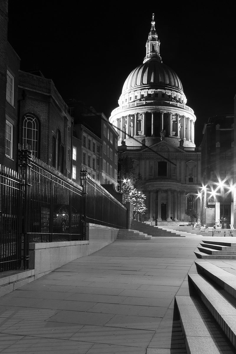 A monochrome of an eerie night scene of an empty London street leading up to St Pauls Cathedral on a late September evening.